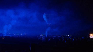 Sıcak hava balonu gökyüzünün altında Samanyolu ve geceleri parlayan yıldızla muhteşem bir Kapadokya üzerinde uçuyor. 