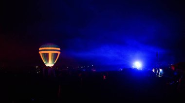 Sıcak hava balonu gökyüzü altında Samanyolu ve geceleri parlayan yıldızla muhteşem bir kapadokya uçuyor.  