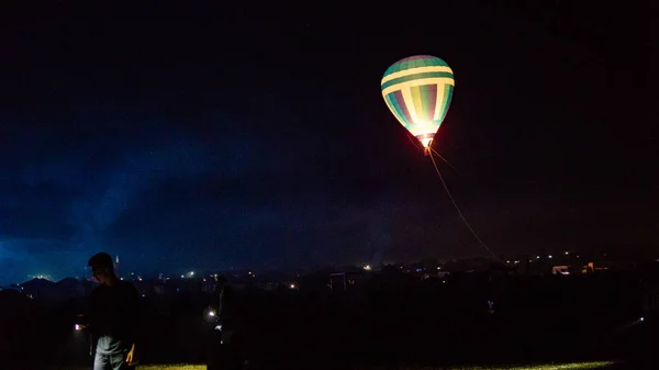 Varm luft ballong flyger över spektakulära Kappadokien under himlen med mjölkaktig sätt och shininng stjärna på natten (med spannmål) — Stockfoto