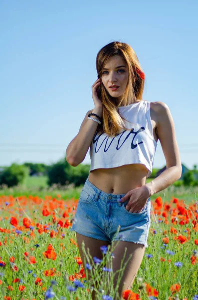 Hübsche Frau im Feld der Mohnblumen — Stockfoto