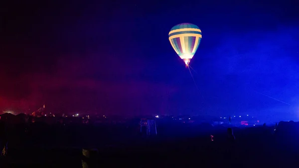 Varm luft ballong flyger över spektakulära Kappadokien under himlen med mjölkaktig sätt och shininng stjärna på natten (med spannmål) — Stockfoto