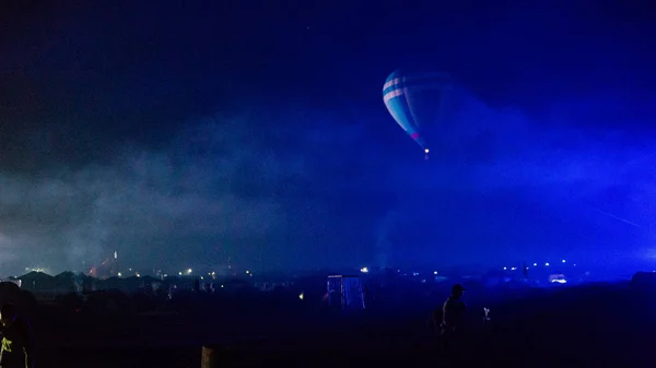 Varm luft ballong flyger över spektakulära Kappadokien under himlen med mjölkaktig sätt och shininng stjärna på natten (med spannmål) — Stockfoto