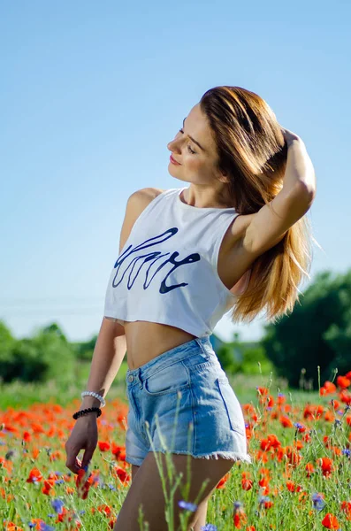 Hübsche Frau im Feld der Mohnblumen — Stockfoto