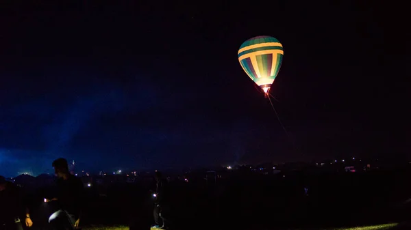 Globo de aire caliente volando sobre la espectacular Capadocia bajo el cielo con la Vía Láctea y la estrella de Shininng en la noche (con grano ) — Foto de Stock