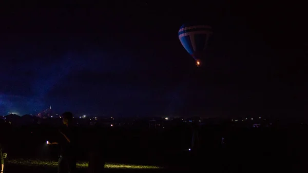 Varm luft ballong flyger över spektakulära Kappadokien under himlen med mjölkaktig sätt och shininng stjärna på natten (med spannmål) — Stockfoto