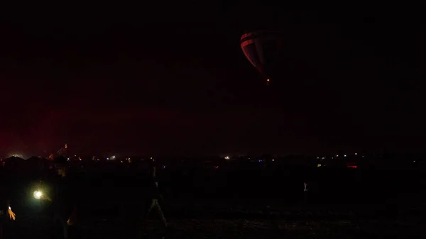 Heißluftballon fliegt über spektakulärem Kappadokien unter dem Himmel mit Milchstraße und leuchtendem Stern in der Nacht (mit Getreide) — Stockfoto