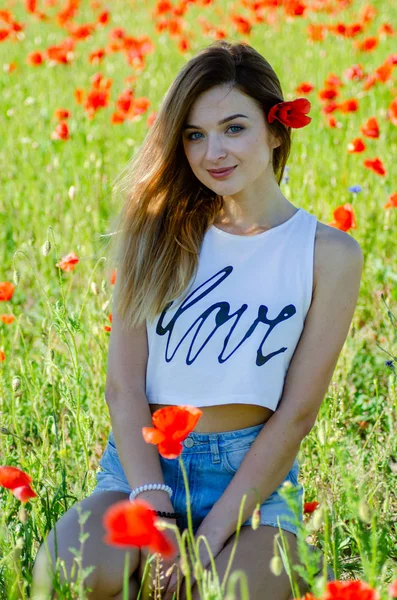 Pretty woman in the field of poppies — Stock Photo, Image