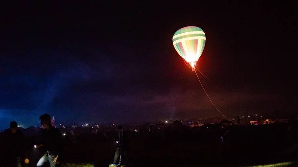 Heißluftballon fliegt über spektakulärem Kappadokien unter dem Himmel mit Milchstraße und leuchtendem Stern in der Nacht (mit Getreide) — Stockfoto