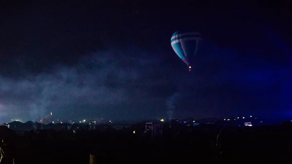 Varm luft ballong flyger över spektakulära Kappadokien under himlen med mjölkaktig sätt och shininng stjärna på natten (med spannmål) — Stockfoto