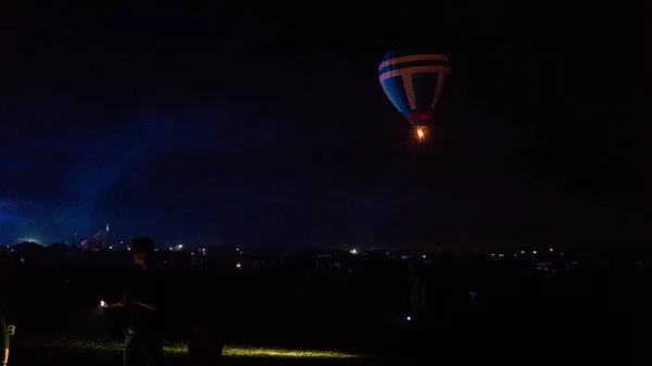 Horkovzdušný balón letící nad velkolepou Cappadocií pod oblohou s mléčnou dráhou a zářící hvězdou v noci (s obilím) — Stock fotografie