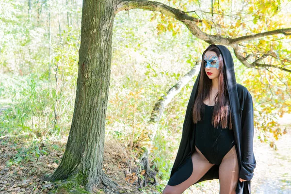 Bela Jovem Mulher Traje Carnaval Preto Máscara Posando Floresta — Fotografia de Stock