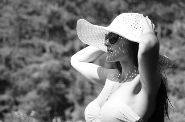 帽子をかぶった女の子が日当たりの良い湖のビーチで — ストック写真
