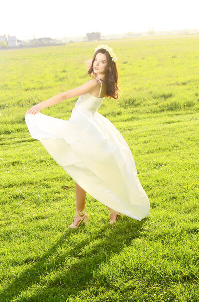 Young beautiful woman in fashionable dress posing outdoors