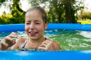Yüzme havuzunda suyu olan mutlu kız.