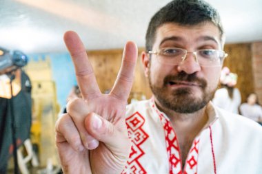 Sakallı ve kırmızı işlemeli gömlekli genç bir adamın portresi..