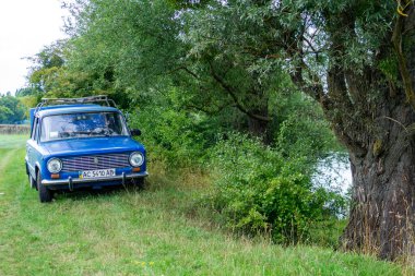 Nehir kenarında eski model bir araba.