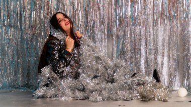 Stüdyoda poz veren parlak noel süsleriyle güzel seksi kadın, tatil konsepti.   