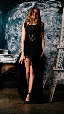 Stüdyoda dantel elbiseyle poz veren genç ve güzel bayan.  