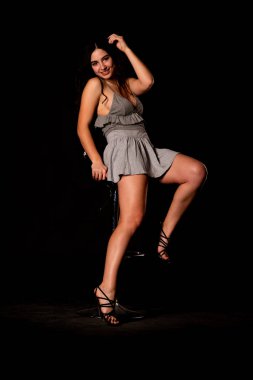 Seksi, güzel, esmer, esmer bir kadın. Kıyafet şortu ve ceket makyajı giyiyor. Ofis tarzı şık bir iş kadını. Resmi elbise. Dalgalı saçlı, çekici bir kız.