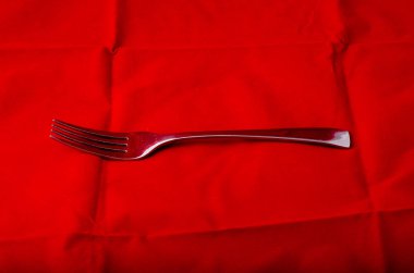 Tekstil arka planına karşı gümüş metal çatal 