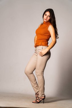 Güzel esmer model, karanlık odada poz veriyor. 