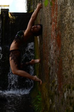 Genç esmer model bir şelale karşı poz