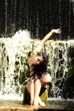 Genç esmer model bir şelale karşı poz