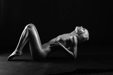 Gümüş rengi vücut boyalı genç atletik kadın.