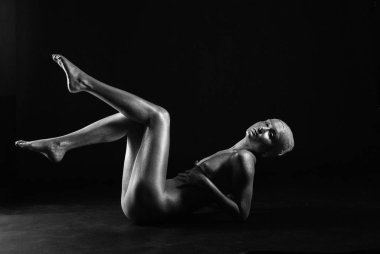 Gümüş rengi vücut boyalı genç atletik kadın.