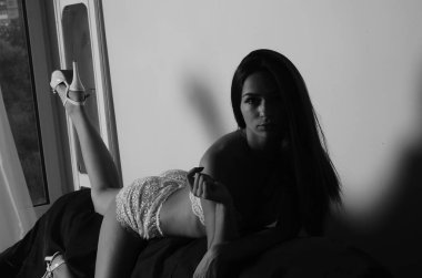 İç çamaşırlarıyla kanepede poz veren sevimli, çekici, çekici bir kızın portresi. 