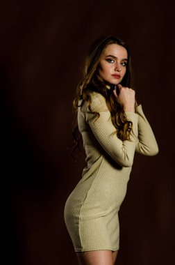 Parlak elbiseli çekici kadın siyah arka planda poz veriyor. 