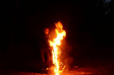 Usta fakir karanlıkta ateş gösterisi sırasında alevlerle gösteri yapıyor..