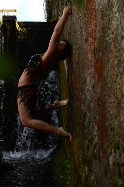 Genç esmer model bir şelale karşı poz