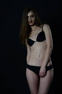 Sarı ceketli, uzun boylu, zarif bir bayan.