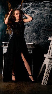 Stüdyoda poz veren narin siyah elbiseli kadın.  