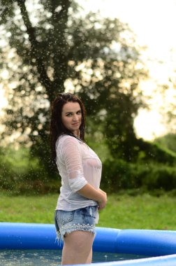 Gün batımında, havuzda ıslak güzel bir kız bedeni..