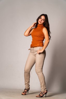 Güzel esmer model, karanlık odada poz veriyor. 