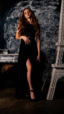 Stüdyoda poz veren narin siyah elbiseli kadın.  