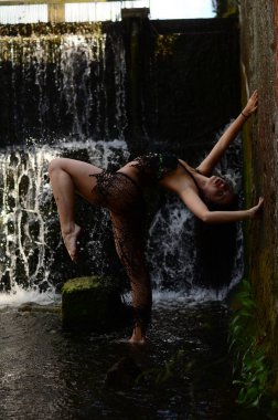 Genç esmer model bir şelale karşı poz