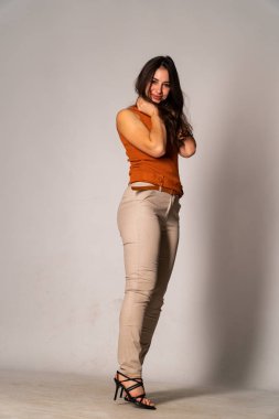 Güzel esmer model, karanlık odada poz veriyor. 