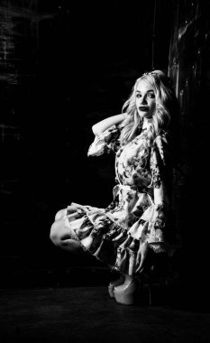 Güzel, şık, sarışın, makyajlı, siyah arka planda saç kesimi olan bir kadın.  