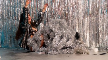 Stüdyoda poz veren parlak noel süsleriyle güzel seksi kadın, tatil konsepti.   