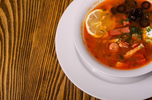 Borsch ucraniano tradicional com nata azeda e feijão branco em um fundo escuro. Sopa de beterraba vegetal vermelha. — Fotografia de Stock