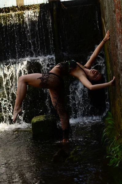 Mladá bruneta model představuje proti vodopád — Stock fotografie
