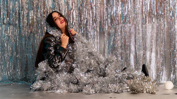 Stüdyoda poz veren parlak noel süsleriyle güzel seksi kadın, tatil konsepti.   