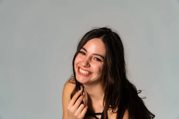 Retrato de la mujer joven desconcertada con ropa ligera mirando a un lado cubriendo la nariz con la mano aislada sobre fondo de pared blanca en estudio. Gente sincera emociones, concepto de estilo de vida. Almacenamiento del espacio de copia — Foto de Stock