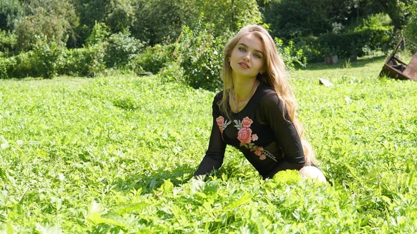 Retrato de uma jovem mulher loira sorridente deitada na grama verde . — Fotografia de Stock