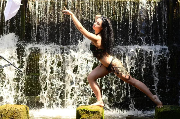 Jonge brunette model poseren tegen een waterval — Stockfoto