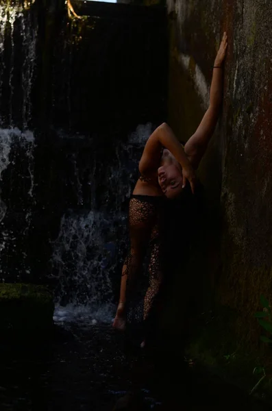 Jonge brunette model poseren tegen een waterval — Stockfoto