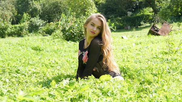 若いです笑顔ブロンド女性の肖像緑の草の上に横たわる. — ストック写真